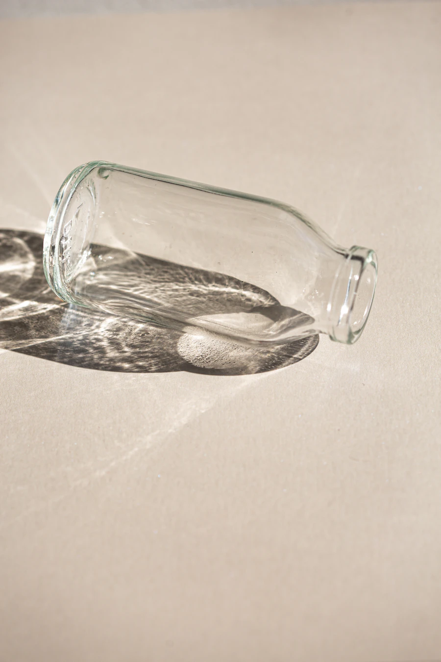 Clear glass bottle with light refraction shadow